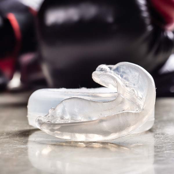 mouth guard with boxing gloves in the background